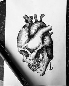 a drawing of a human heart on paper next to a pen and ink rollers