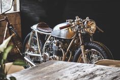 two motorcycles parked next to each other on a wooden table in front of a window