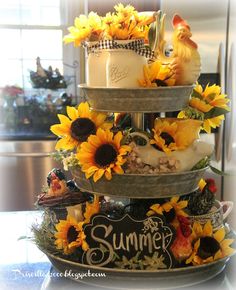 a three tiered tray with sunflowers and candles