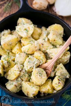 potato salad in a skillet with a wooden spoon