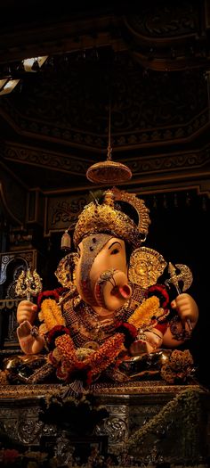 a statue of ganesh in the middle of a room filled with flowers and other decorations