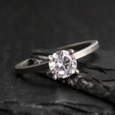 a diamond ring sitting on top of a rock