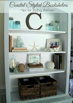 a white book shelf with baskets and books on it's shelves, along with other items