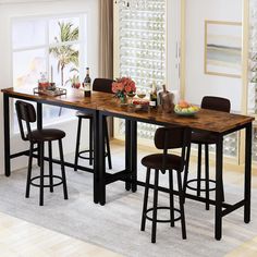 a dining table with four stools in front of it