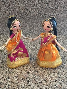 two little figurines that are standing next to each other