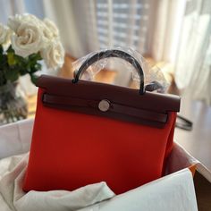 Authentic With Receipt. Herbag Zip 31 Bag Color: Orange Mcano/Rouge H Measurements Width:9.8 In Height:12.2 In Depth:3.9 In Brand New With Original Tags, Box, Dust Bag And Receipt. High-end Red Shoulder Bag With Top Carry Handle, High-end Red Shoulder Bag With Top Handle, High-end Red Shoulder Bag, High-end Red Bag With Detachable Handle, Designer Red Bags With Detachable Handle, Luxury Red Top Handle Bag, High-end Red Bag For Everyday Use, High-end Red Shopping Bag, High-end Red Shoulder Bag With Double Handle