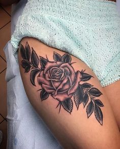 a woman's thigh with a rose tattoo on it