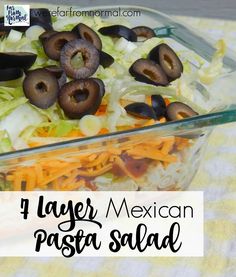 mexican pasta salad with black olives and lettuce in a glass casserole dish