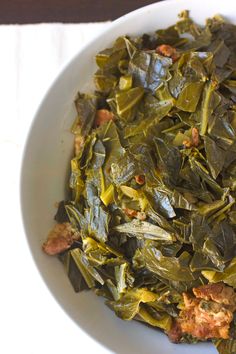 a white bowl filled with collard greens on top of a table