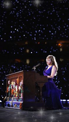 a woman in a purple dress standing at a podium