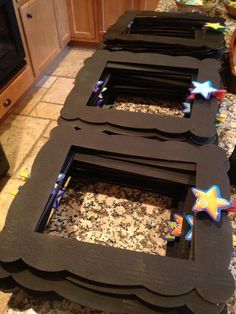 three black frames sitting on top of a counter in the middle of a kitchen area