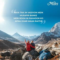 two people sitting on top of a rock with mountains in the background and an advertisement for miles