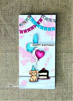 a birthday card with a dog holding balloons and a slice of cake on the table