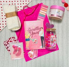 the contents of a valentine's day gift bag are laid out on a bed