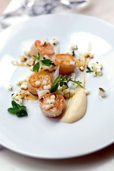 a white plate topped with shrimp and garnish on top of a wooden table