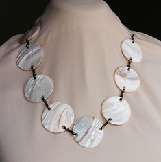 Vintage Hawaii necklace with large mother of pearl polished white shells linked with brass loops. Fine example of boho chic tourist souvenir jewelry from the 1960s-70s. Set with 14 large shell discs. Neclace length is 70 cms. Shells are 4 cms wide in diameter. Rare! Suitable as a fine vintage gift for her into luxury boho hippie chic jewelry. Pre-owned, in a good used condition. Shiny beautiful mother of pearl discs. Somewhat darkened brass metal. (May of course be polished with metal polish). W Hawaii Necklace, 1970 Style, Hippie Chic Jewelry, Luxury Boho, White Shells, Souvenir Jewelry, Vintage Hawaii, Boho Hippie Chic, Chic Jewelry