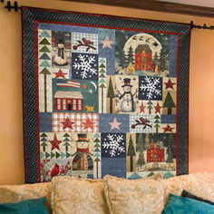 a quilted wall hanging on the side of a bed