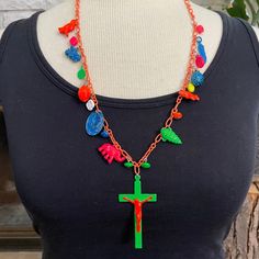 a woman wearing a black shirt with a red cross and multicolored beads on it