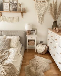 a bed room with a neatly made bed and lots of decor on the wall above it