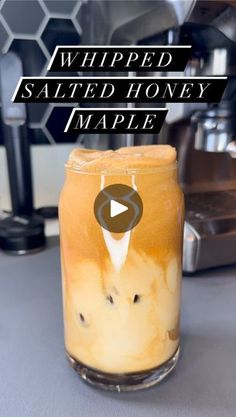 a glass jar filled with liquid sitting on top of a counter next to an espresso machine