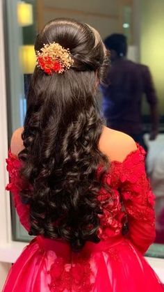 the back of a woman's head wearing a red dress with flowers in her hair