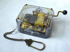 a small clock with a chain attached to it