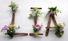 flowers arranged in the shape of letters made out of sticks