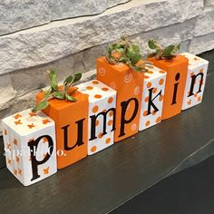 three pumpkin blocks with the word pumpkin painted on them