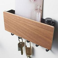 there is a wooden shelf with keys on it and a card holder attached to the wall