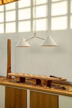 a wooden bench sitting under two lights in a room