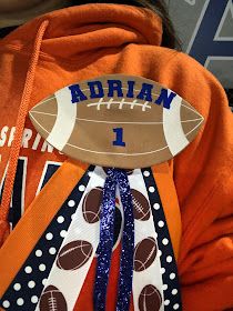 a person wearing an orange hoodie with a football decoration on it's neck