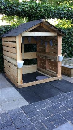 a dog house made out of wooden pallets