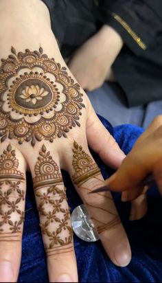 a woman's hand with henna tattoos on it