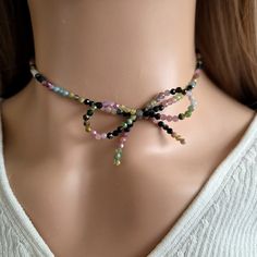 Indulge in the ultimate luxury with our Beaded Bow Necklace featuring colorful natural Tourmaline beads. This exquisite piece exudes elegance and charm, making it the perfect gift for her. Handcrafted with meticulous detail, this coquette jewelry piece is a true work of art. Beautiful handmade jewelry. The intricate design of the bow choker for women showcases delicate beadwork and a striking bow tie pendant that will surely make a statement wherever you go. ♥ HIGH QUALITY MATERIALS ♥ This adjus Multicolor Faceted Beads Crystal Necklace As Gift, Multicolor Gemstone Bead Choker Necklace, Multicolor Crystal Necklace With Faceted Beads As Gift, Multicolor Gemstone Beads Choker Necklace, Multicolor Gemstone Beaded Choker Necklace, Elegant Multicolor Round Beads Choker, Bohemian Multicolor Gemstone Beads Choker, Elegant Handmade Rainbow Beaded Necklaces, Multicolor Crystal Necklace With Polished Beads For Gifts