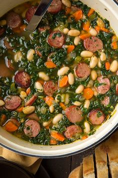 a bowl filled with sausage, beans and greens