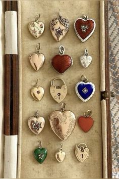 a box filled with lots of different types of heart shaped pendants on top of a table