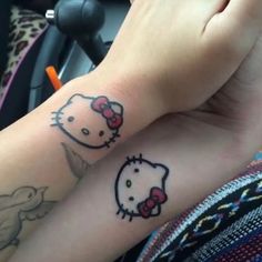 two hello kitty tattoos on the arms of someone's arm, one with a bow