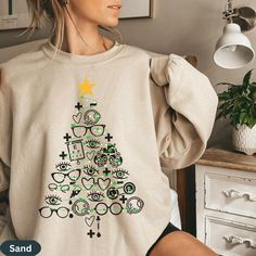 Looking for a ugly Christmas sweater gift for your optometry office team or optometrist?   Sparkle this Christmas with these cute Christmas crewneck Optometry symbols and eyeglasses Christmas tree sweatshirts.  They are perfect for any optometry office staff, optometry assistant, optometry school student, or optometrist or optician to wear to work.  Plus, they make great staff appreciation gifts for your new optometry school graduate or whole eye doctor team, and make a lovely gift for a coworke Halloween Optometry, Optometrist Christmas Tree, Optometry Assistant, Opthalmic Technician Shirts, Optometry Tshirt, Office Xmas Party, Opthamologist Eye Doctor, Optometry School, Optometry Office