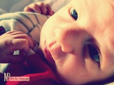 a close up of a baby laying on top of a bed