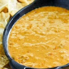 a black pan filled with soup next to tortilla chips