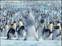 penguins are standing in the snow with their arms up and one penguin is raising his hands