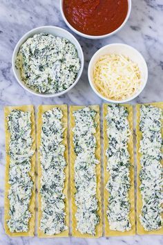 the ingredients to make spinach and cheese ravioli laid out on a marble surface