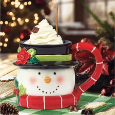 a snowman mug with whipped cream and candy canes on it's head