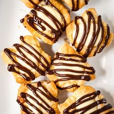 chocolate drizzled on top of pastries on a white plate