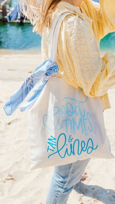 a woman is walking on the beach carrying a bag that says goodbye times and smiles