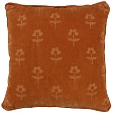 an orange pillow with white flowers on the front and back, against a white background