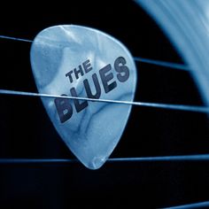 a guitar pick with the words the blues on it