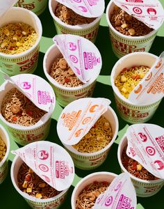 several cups filled with different types of food on top of a green tableclothed surface