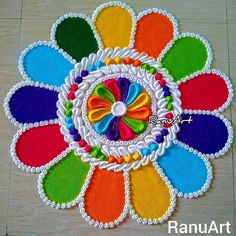 a colorful flower made out of felt on a wooden floor with the words rang art written below it