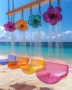 colorful glass flowers hanging from chains on the beach